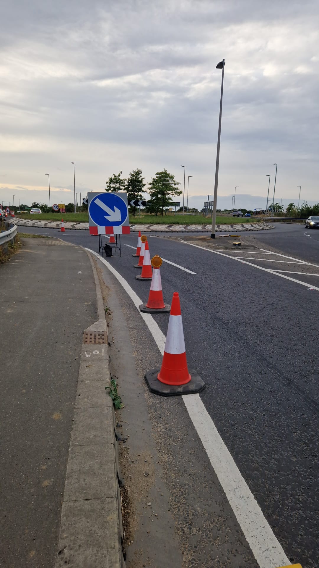 Cones and arrow sign directing traffic into a roundabout on a low-speed scheme