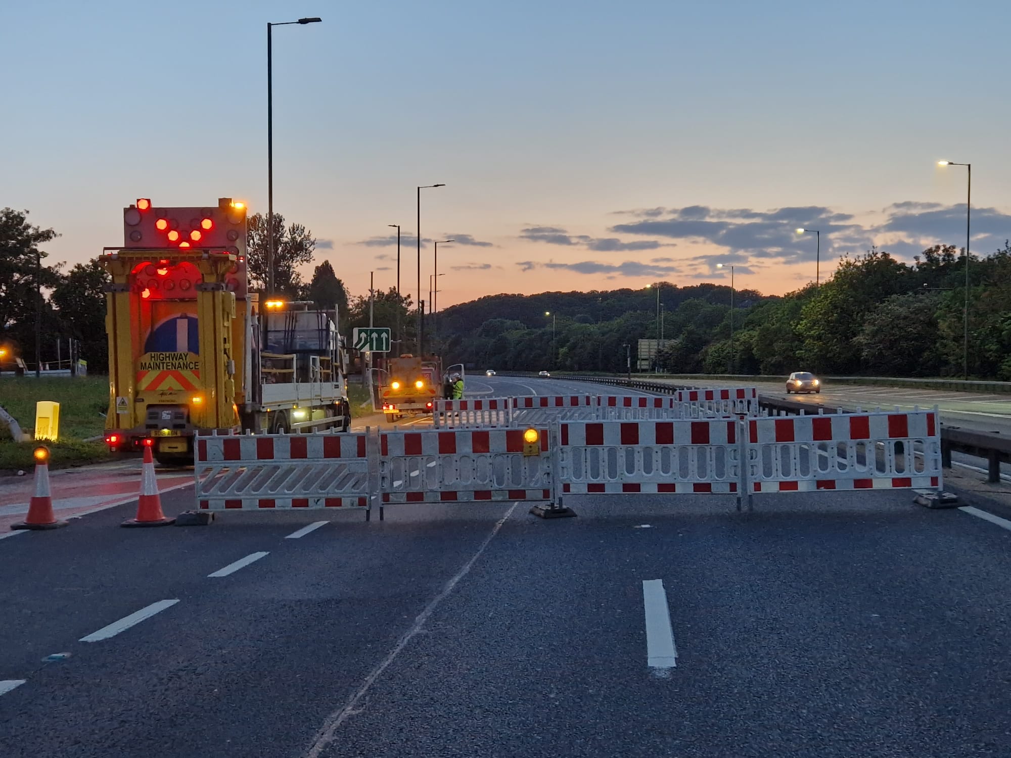 Motorway lane closure with barriers and a highway maintenance vehicle
