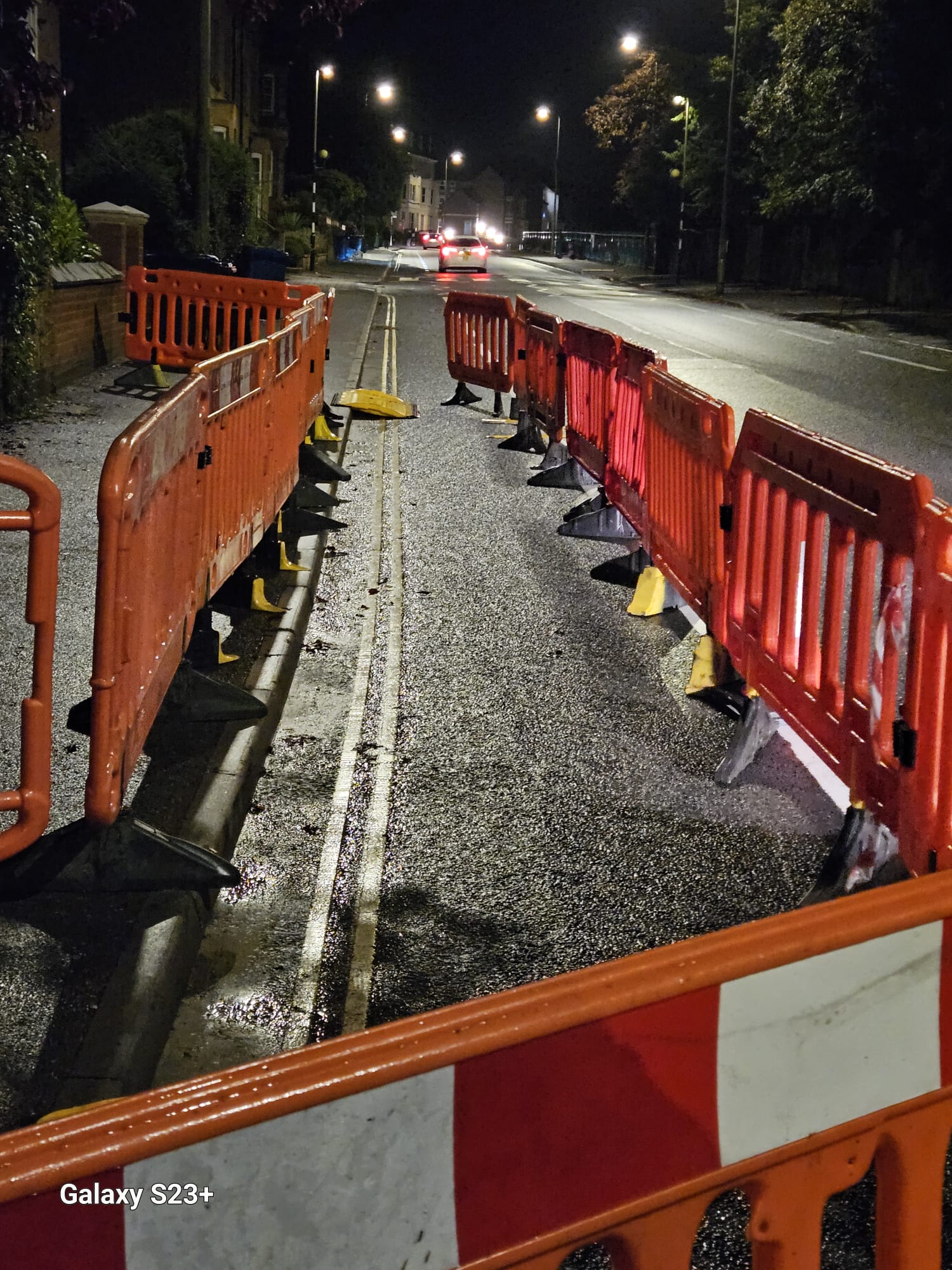 Barriers separating a night-time work zone from traffic on a wet road
