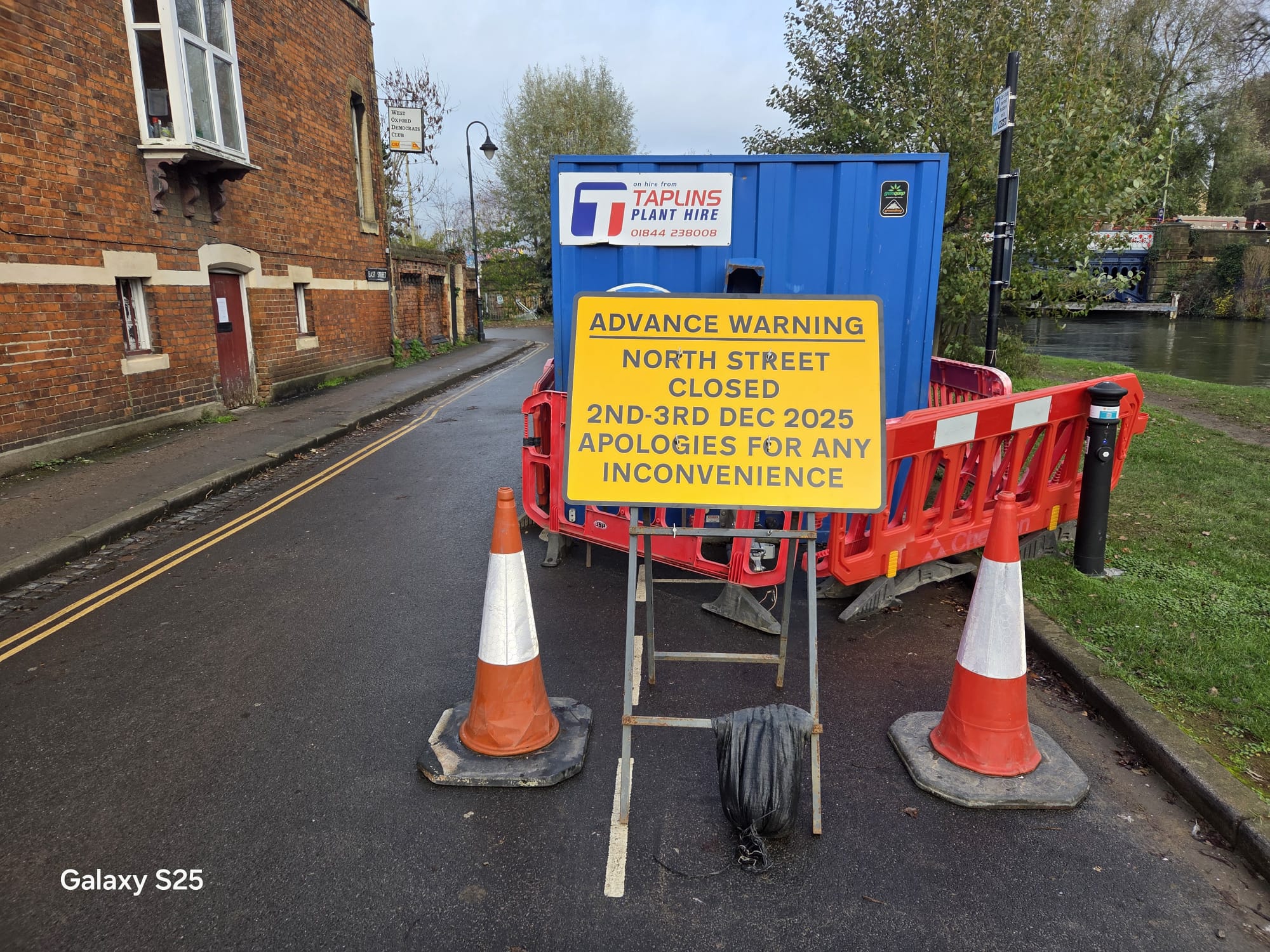 Yellow advance warning sign on cones giving notice of a street closure and its dates
