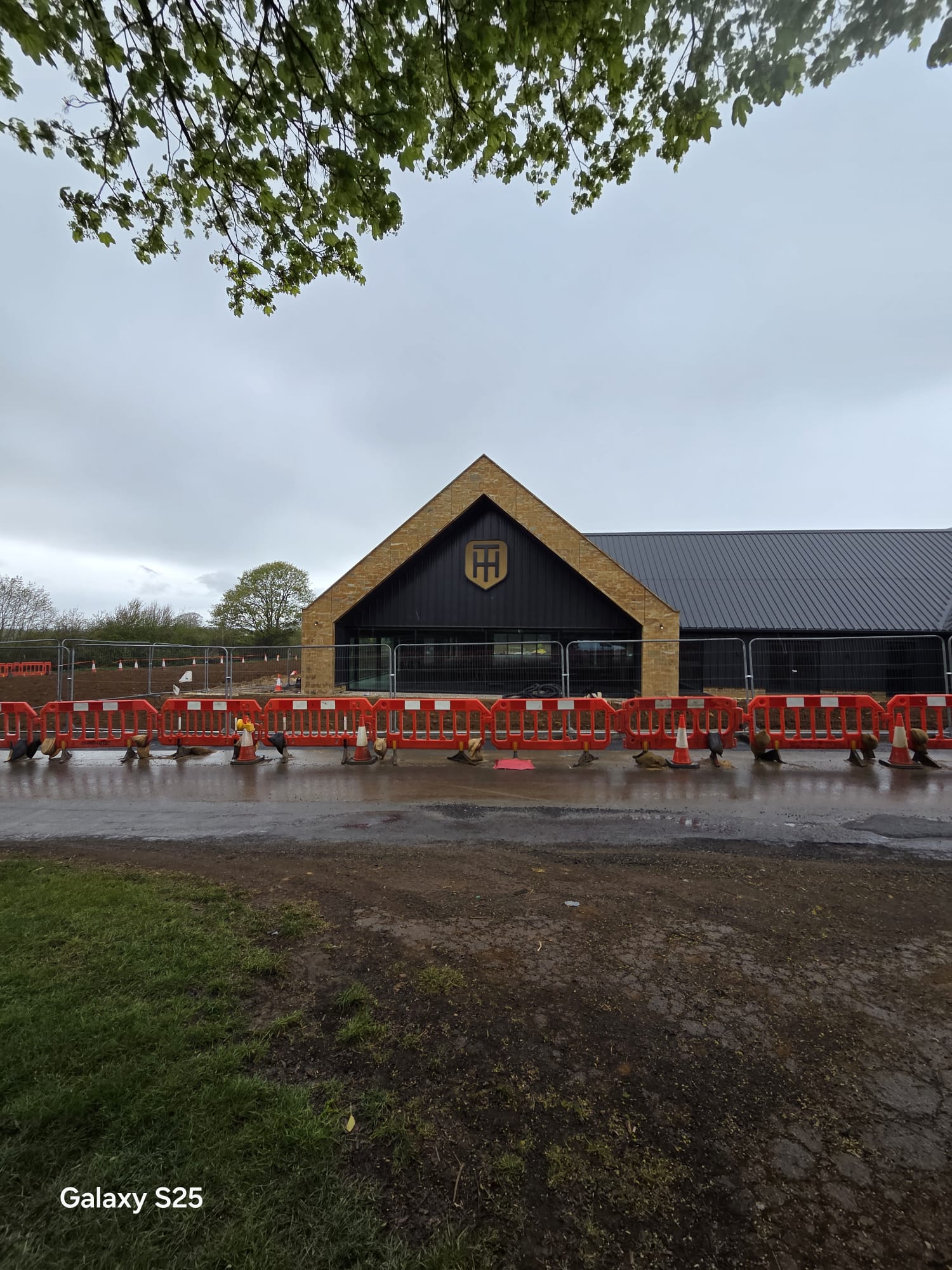 Continuous line of red traffic management barriers segregating a construction site from the carriageway