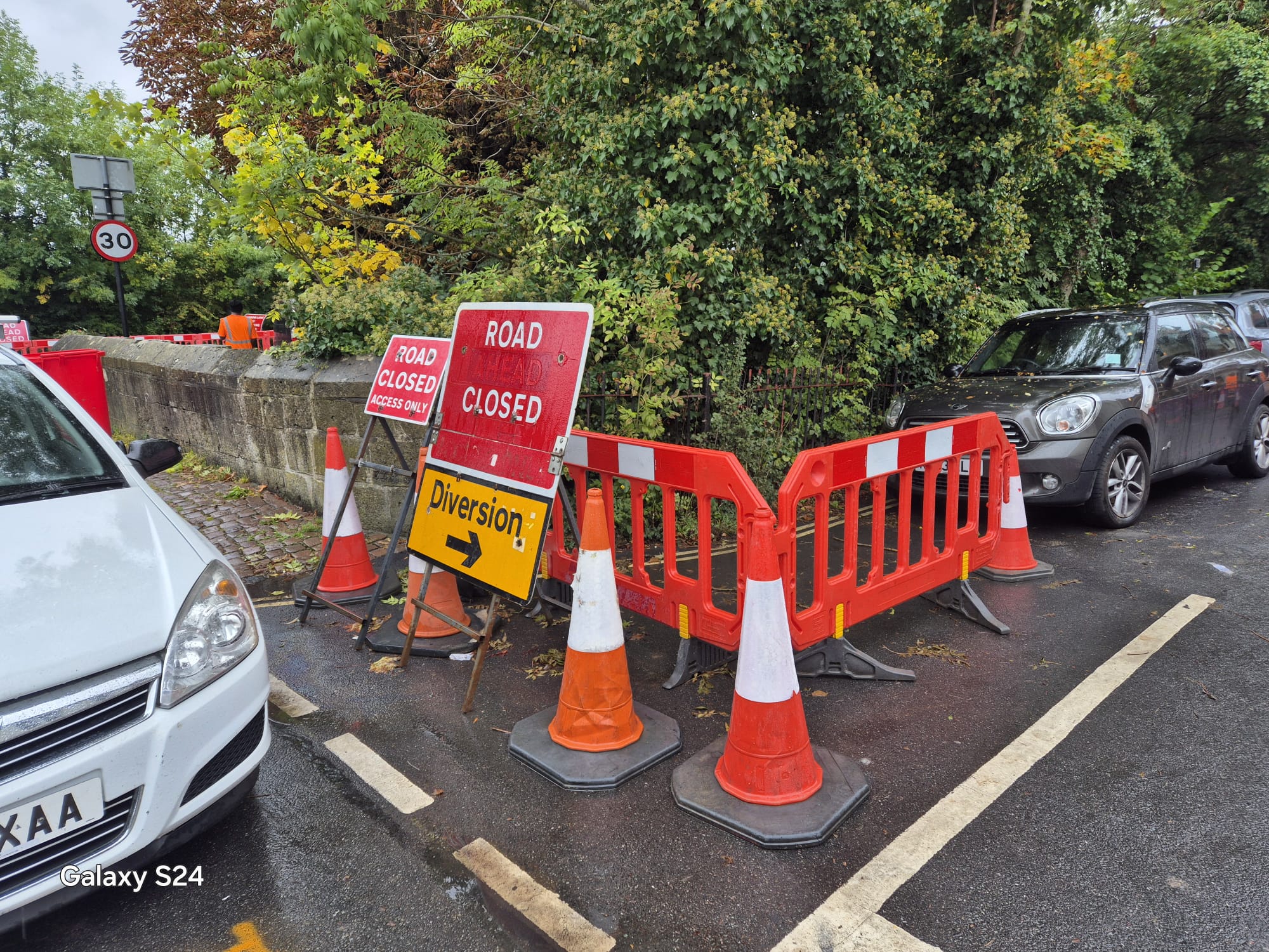 Road closed signs and diversion signage blocking a street corner