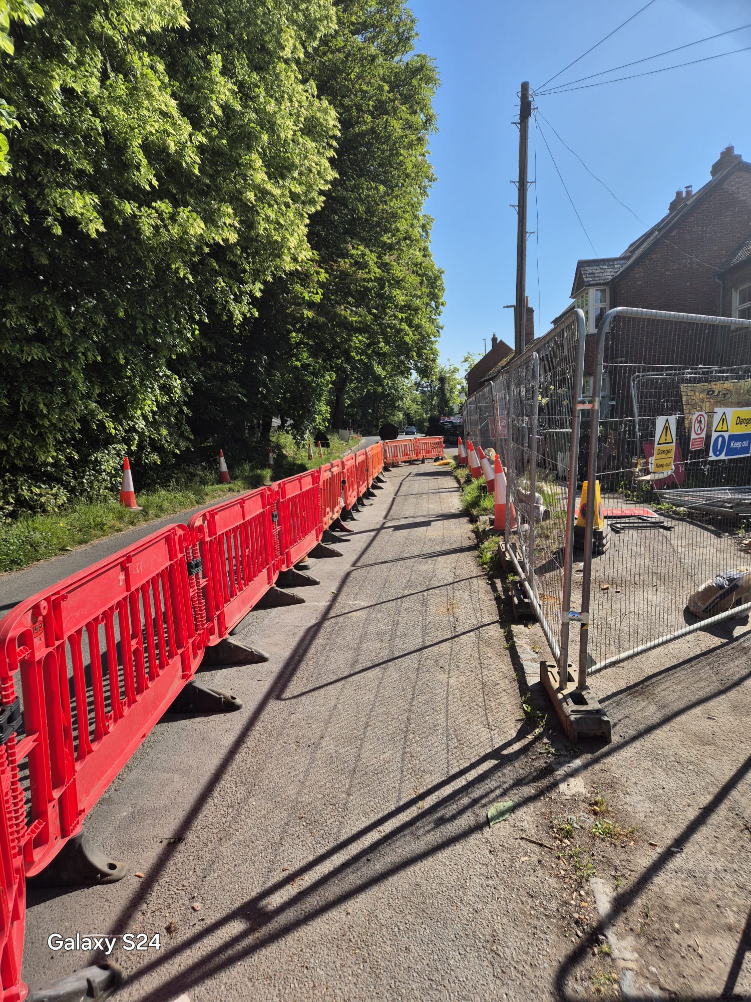 Temporary pedestrian corridor formed by barriers and fencing on a sunny day